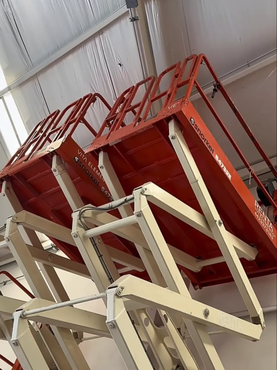 Plataformas de tijera Snorkel elevadas dentro de bodega