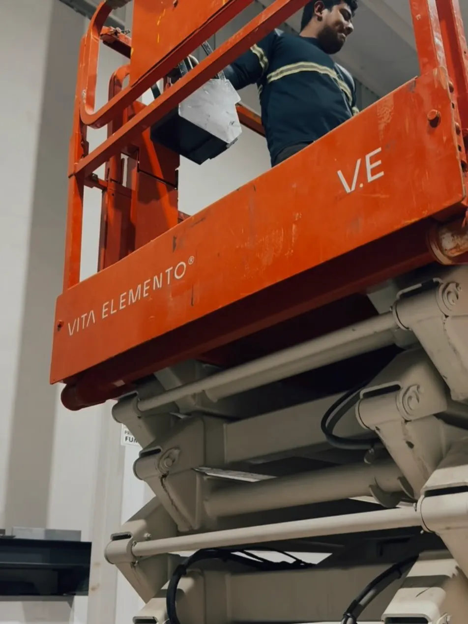 Operador en plataforma de tijera naranja de Vita Elemento